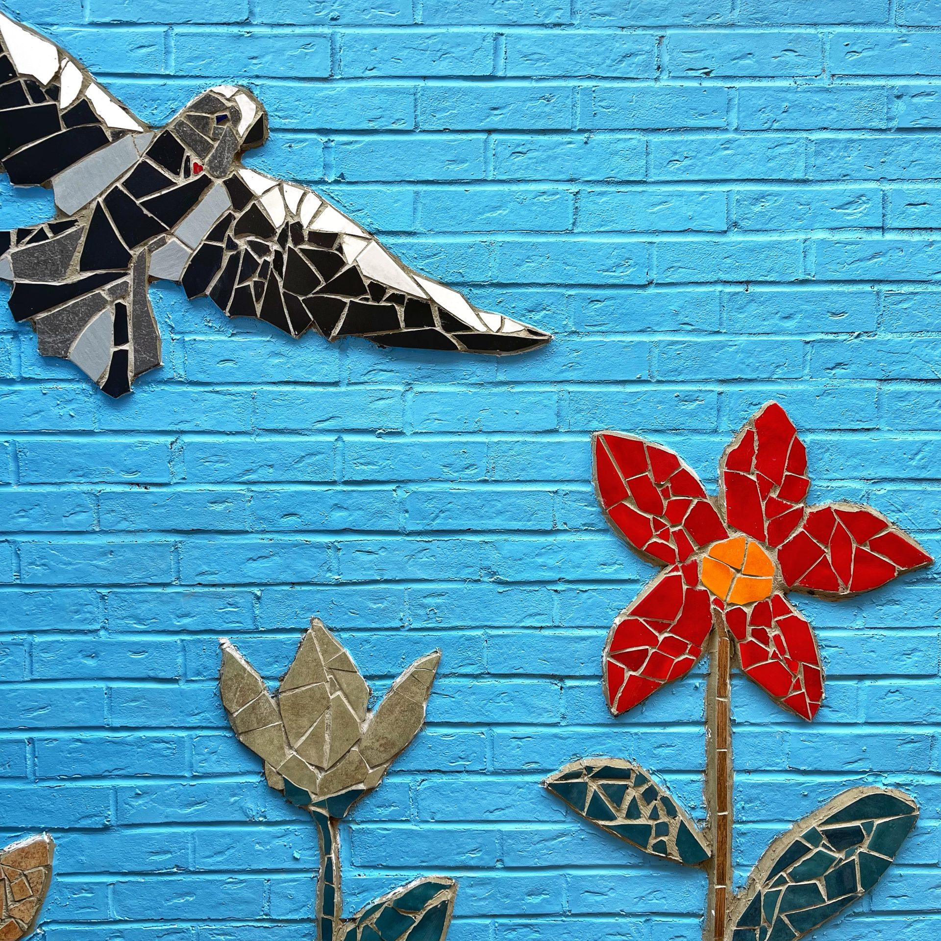 blue wall with mosaic bird and flowers