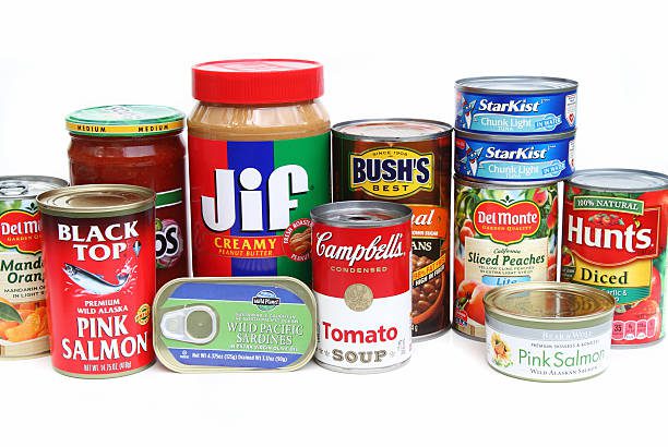 West Palm Beach, USA - October 8, 2014:  A studio shot of an assortment of canned foods. Foods include Campbell's tomato soup, Bush's baked beans, Del Monte peaches and mandarin oranges,  Star Kist tuna, Hunts diced tomatoes, Wild Planet sardines, Jif peanut butter, and Bear and Wolf salmon. These products are basic grocery staples found in many American kitlchens.